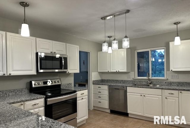 kitchen featuring white cabinetry, sink, decorative light fixtures, and appliances with stainless steel finishes