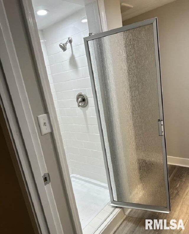 bathroom with walk in shower and hardwood / wood-style flooring