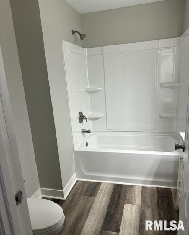 bathroom with hardwood / wood-style flooring, toilet, and tub / shower combination