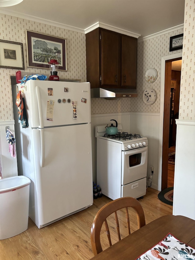 kitchen with ornamental molding, dark brown cabinets, white appliances, and light wood-type flooring