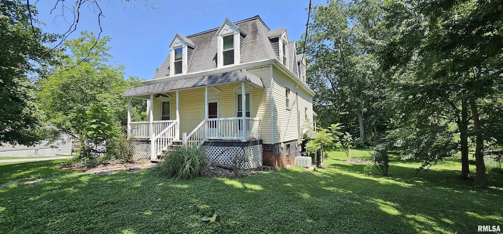 view of front facade with central AC, a front yard, and covered porch