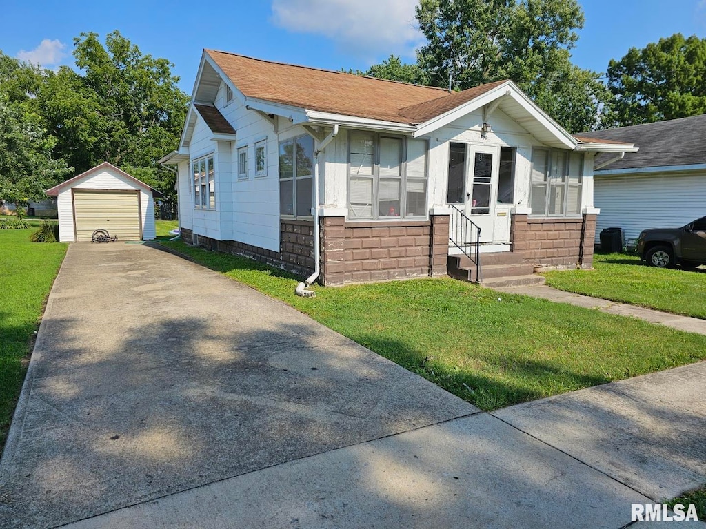 view of front of property with a garage, an outbuilding, and a front yard