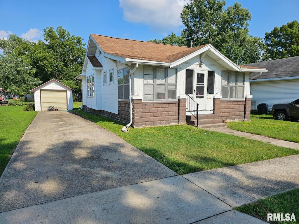 view of front facade with a garage, a front lawn, and an outbuilding