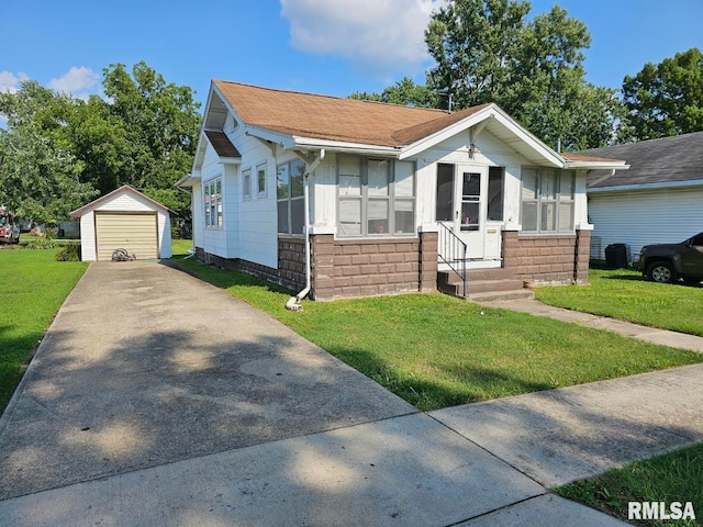 view of front facade with a garage, a front lawn, and an outbuilding