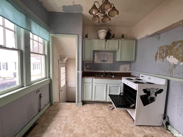 kitchen featuring sink, a chandelier, and white range with electric stovetop