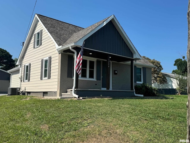 view of front of home with central AC, covered porch, and a front lawn