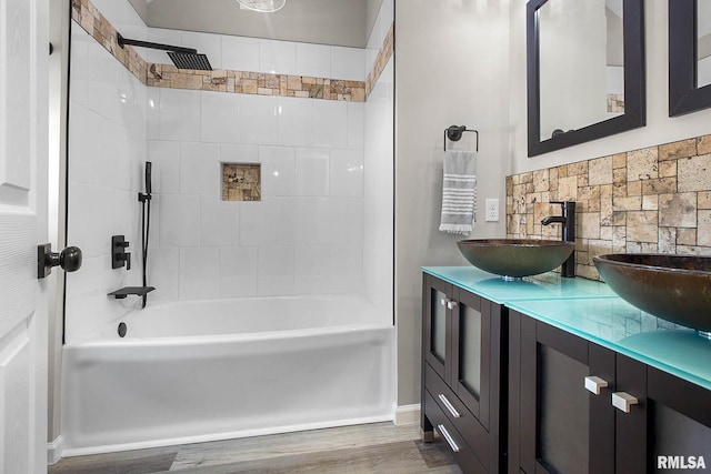 bathroom featuring vanity, hardwood / wood-style floors, and tiled shower / bath