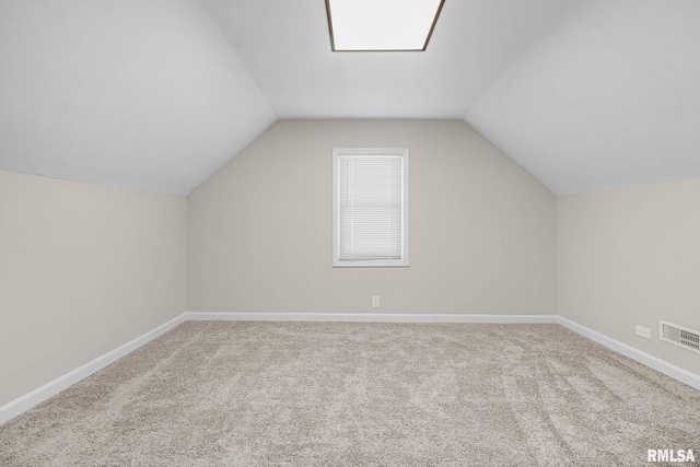 additional living space featuring lofted ceiling and light carpet