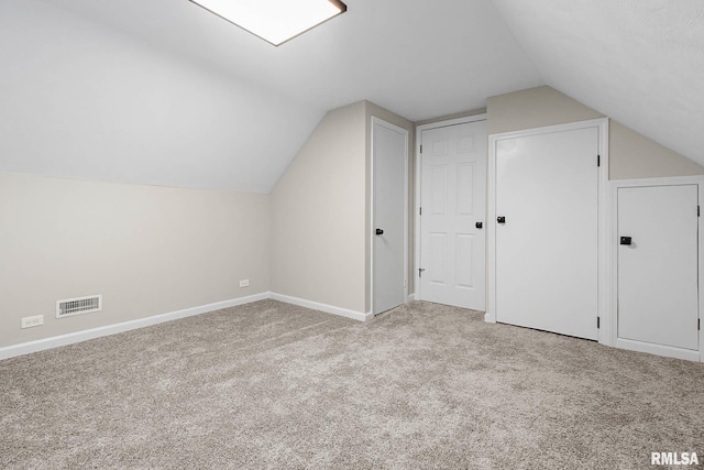 additional living space featuring lofted ceiling and light carpet