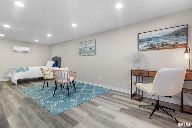 bedroom with light hardwood / wood-style flooring and a wall mounted AC