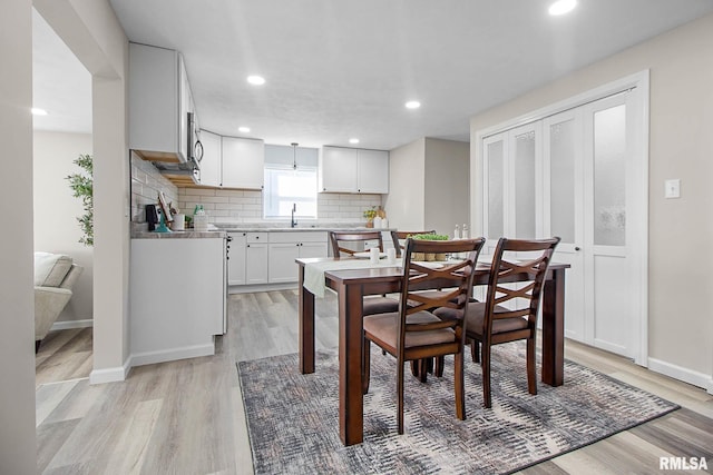 dining room featuring sink and light hardwood / wood-style flooring