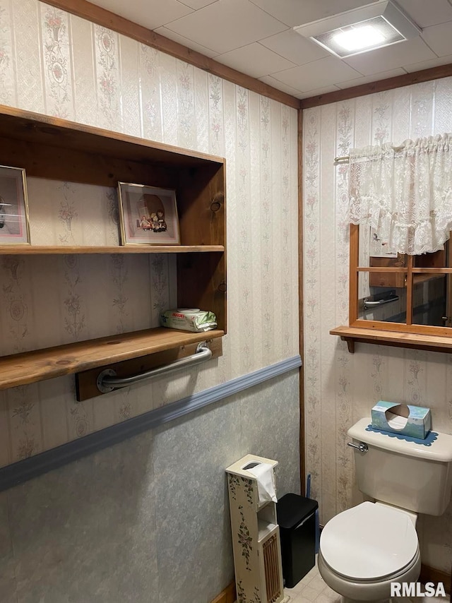 bathroom featuring a paneled ceiling and toilet