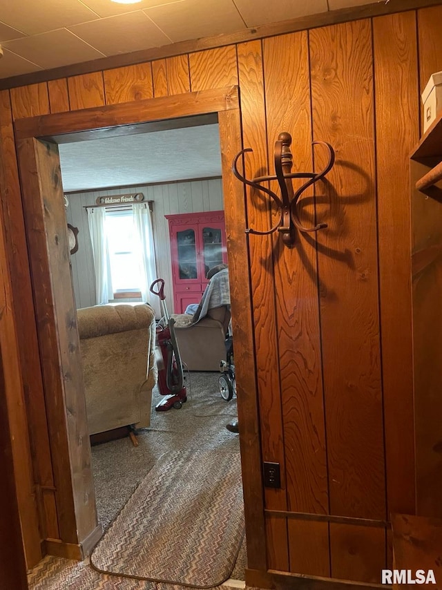 hall with carpet flooring and wooden walls