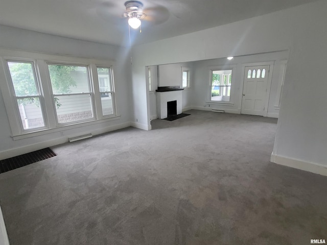 unfurnished living room with ceiling fan and carpet flooring