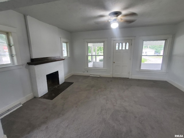 unfurnished living room featuring dark carpet and a brick fireplace