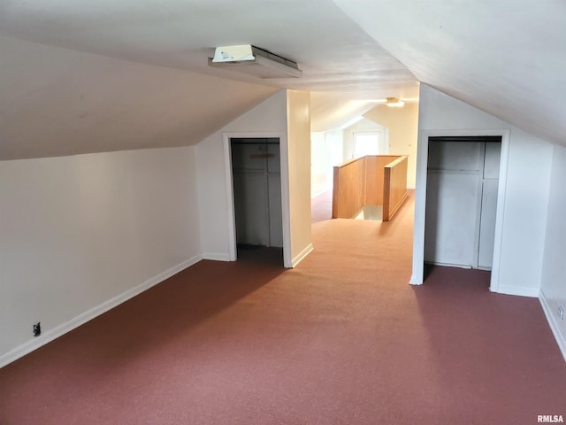 bonus room with lofted ceiling and carpet flooring