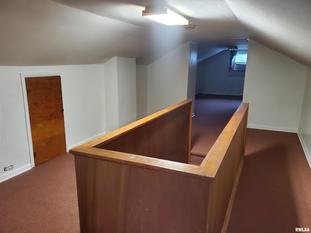 bonus room with vaulted ceiling and dark carpet