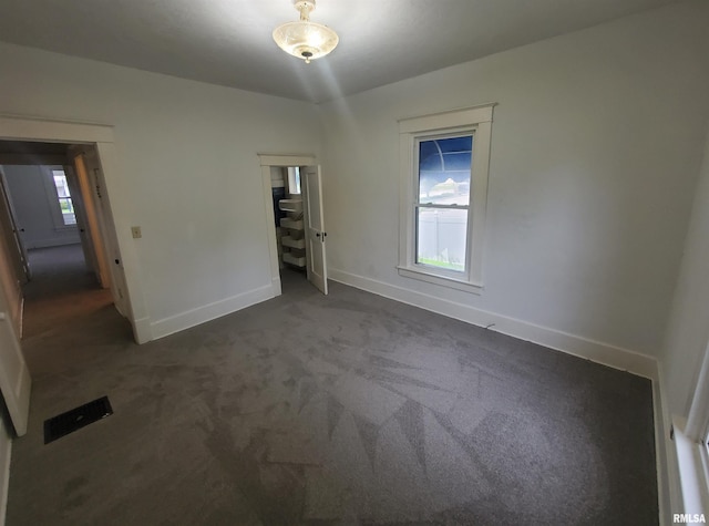 unfurnished room with dark colored carpet