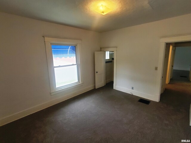 unfurnished bedroom featuring dark carpet