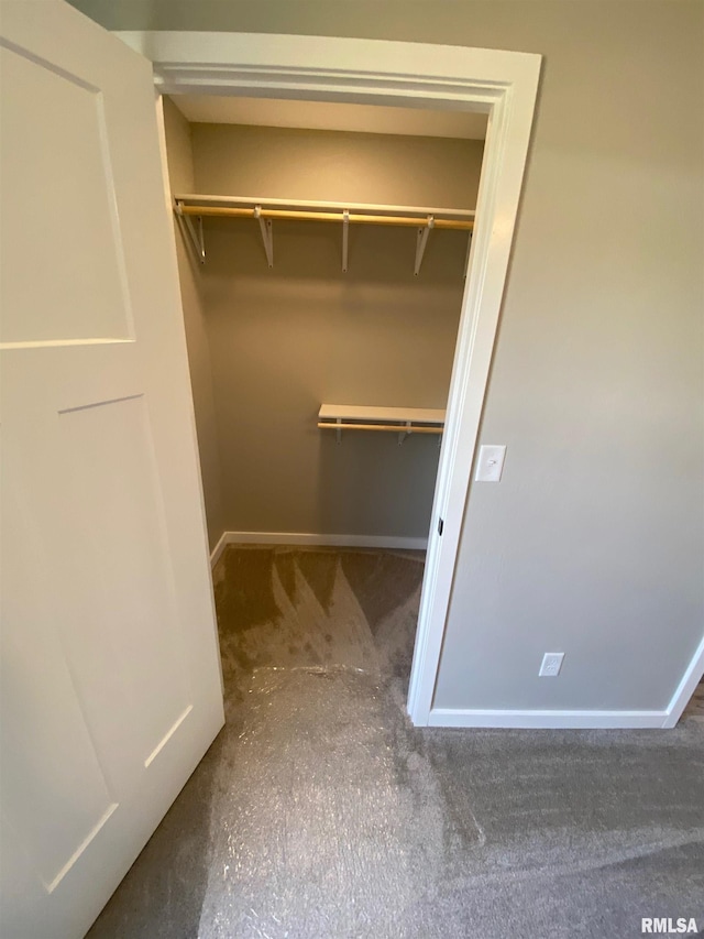 spacious closet featuring dark colored carpet