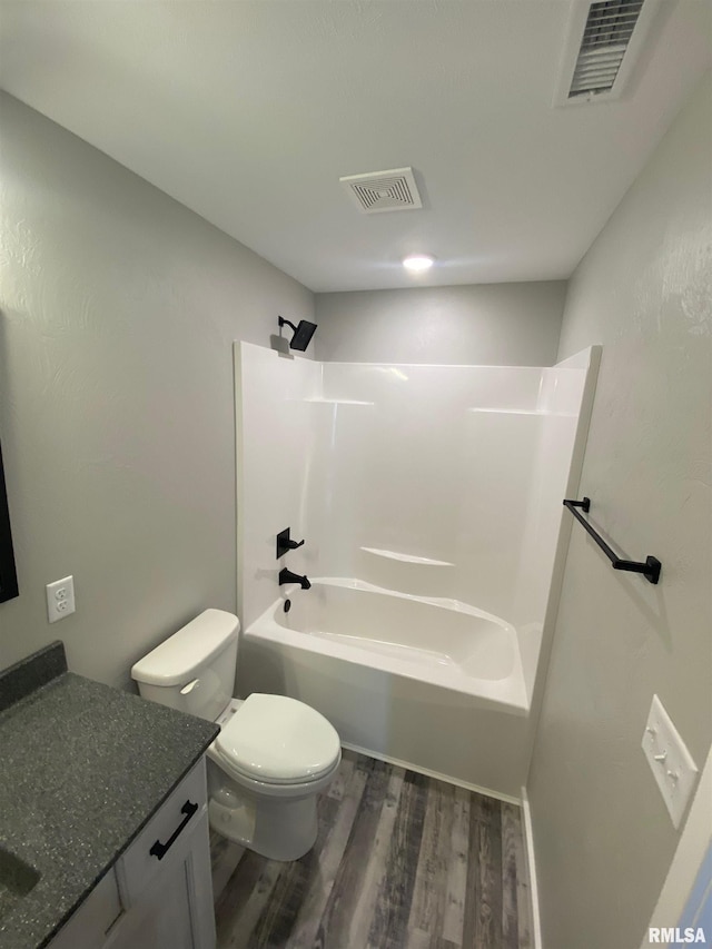 full bathroom featuring washtub / shower combination, wood-type flooring, vanity, and toilet