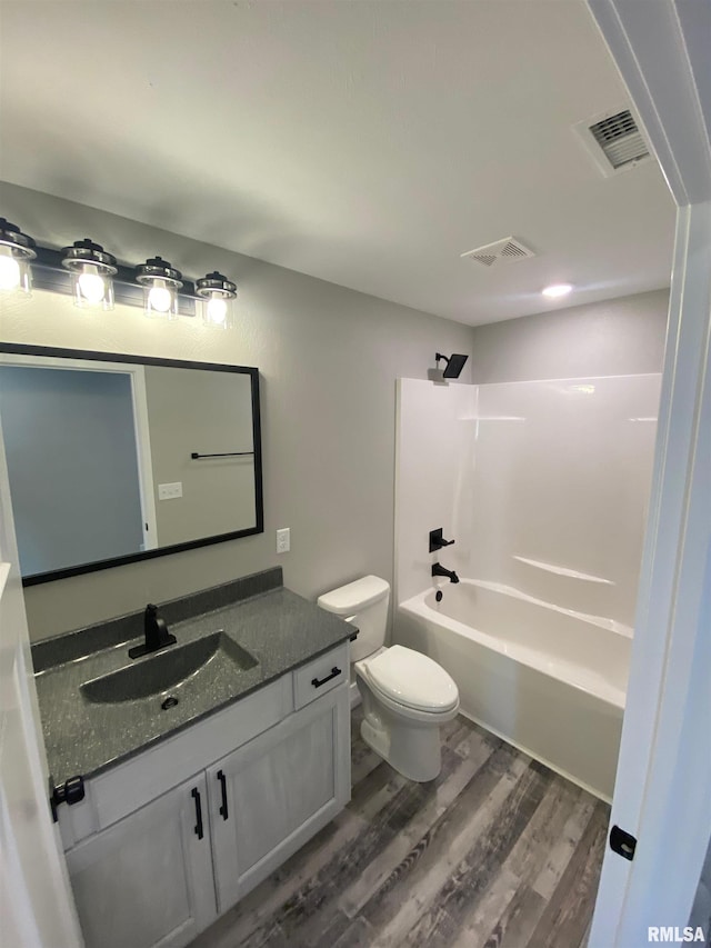 full bathroom with bathing tub / shower combination, vanity, toilet, and hardwood / wood-style flooring