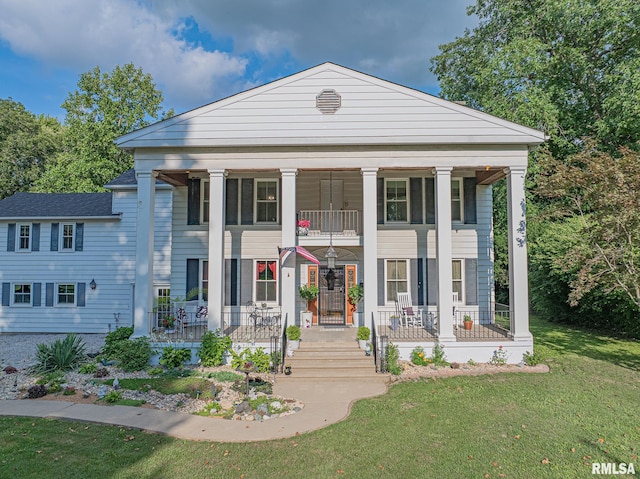 neoclassical / greek revival house featuring a porch and a front yard