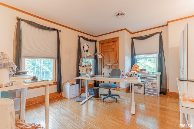 home office with light hardwood / wood-style flooring, a wealth of natural light, and crown molding