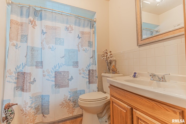 bathroom with vanity, tile walls, toilet, and decorative backsplash