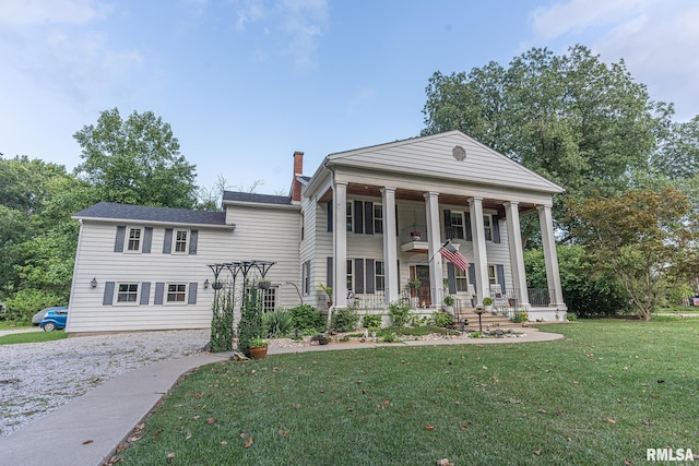 greek revival house with a front yard and a porch