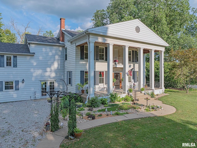 greek revival house with a front lawn and a porch