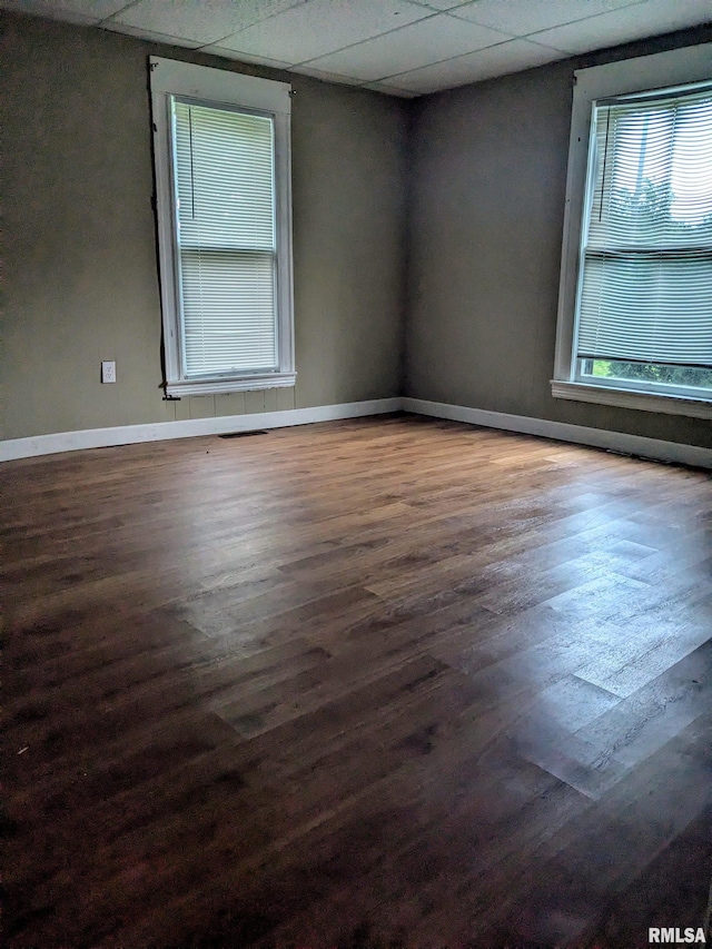 empty room featuring a paneled ceiling and hardwood / wood-style flooring