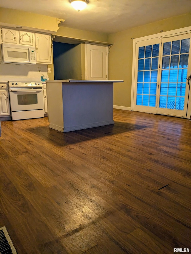 kitchen with white cabinets, white appliances, and dark hardwood / wood-style floors