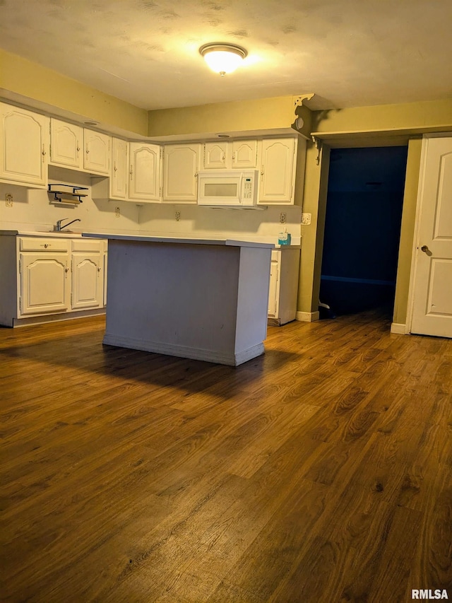 kitchen featuring sink, dark wood-type flooring, dishwashing machine, and white cabinetry