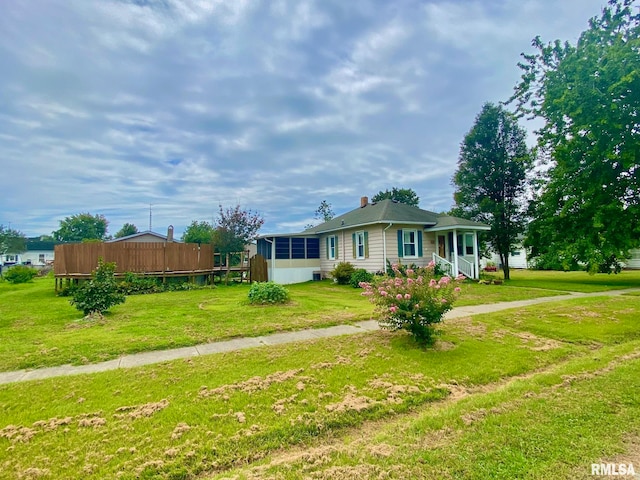 view of front facade featuring a sunroom and a front lawn