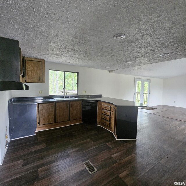 kitchen with a wealth of natural light, black dishwasher, and dark hardwood / wood-style floors