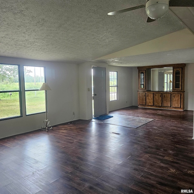 empty room with a textured ceiling, ceiling fan, and dark hardwood / wood-style floors