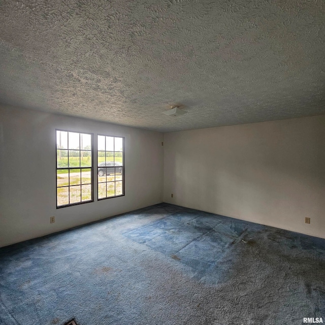 empty room featuring a textured ceiling and carpet floors