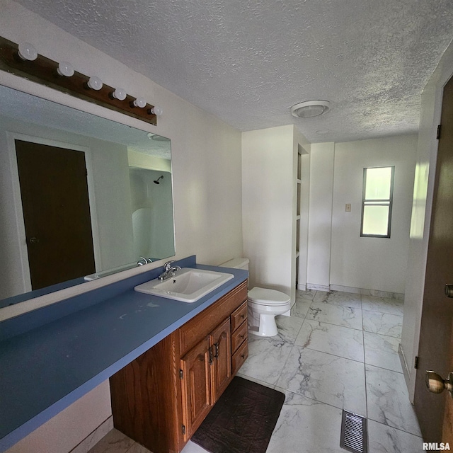 bathroom featuring a textured ceiling, vanity, and toilet