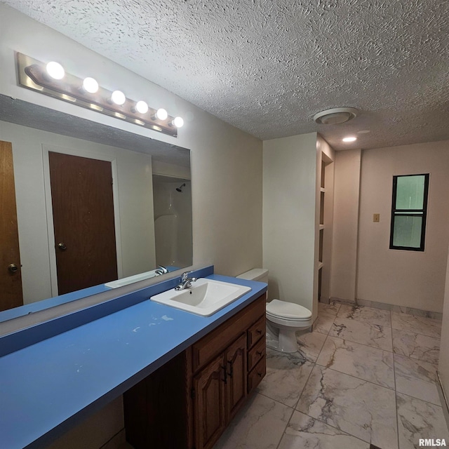 bathroom featuring vanity, toilet, and a textured ceiling