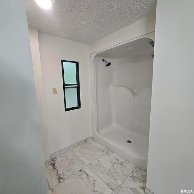 bathroom featuring walk in shower and a textured ceiling