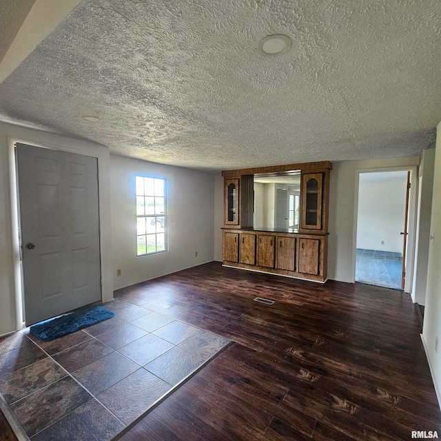 foyer featuring a textured ceiling and dark hardwood / wood-style floors