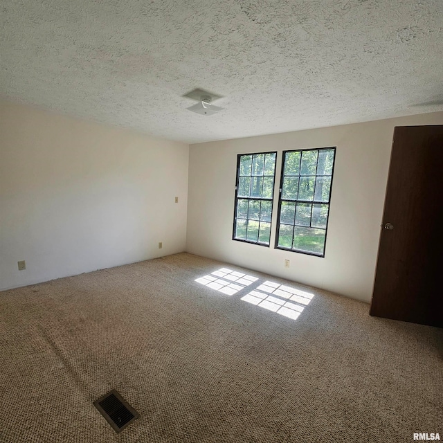 carpeted spare room featuring a textured ceiling