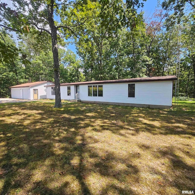 view of front facade with an outbuilding, a front yard, and a garage