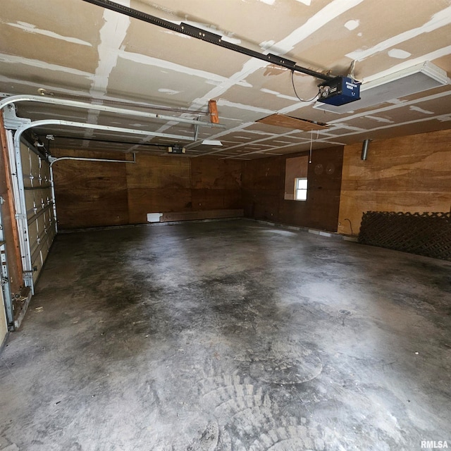 garage with wood walls and a garage door opener