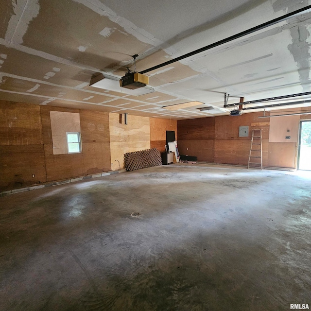 garage featuring a garage door opener and wooden walls