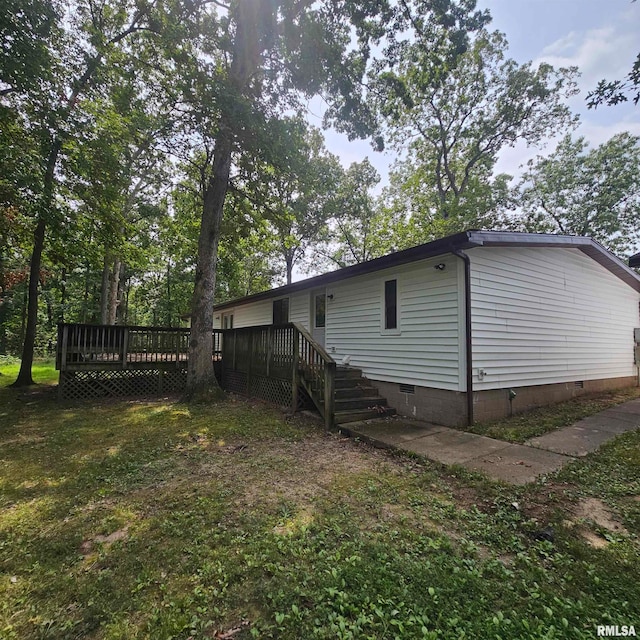 rear view of property featuring a lawn and a deck