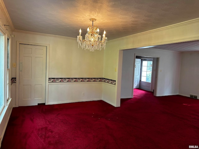 carpeted spare room featuring a notable chandelier and crown molding