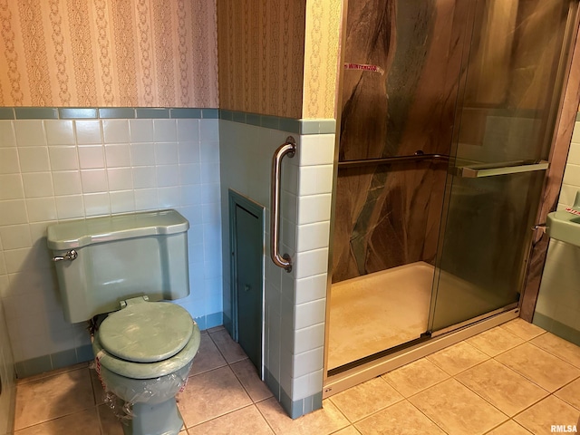 bathroom with a shower with shower door, tile patterned floors, and toilet