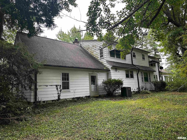 back of house featuring central AC and a yard